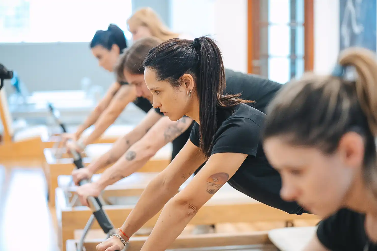 Alumnas entrenando con guía profesional en la sala de Reformer