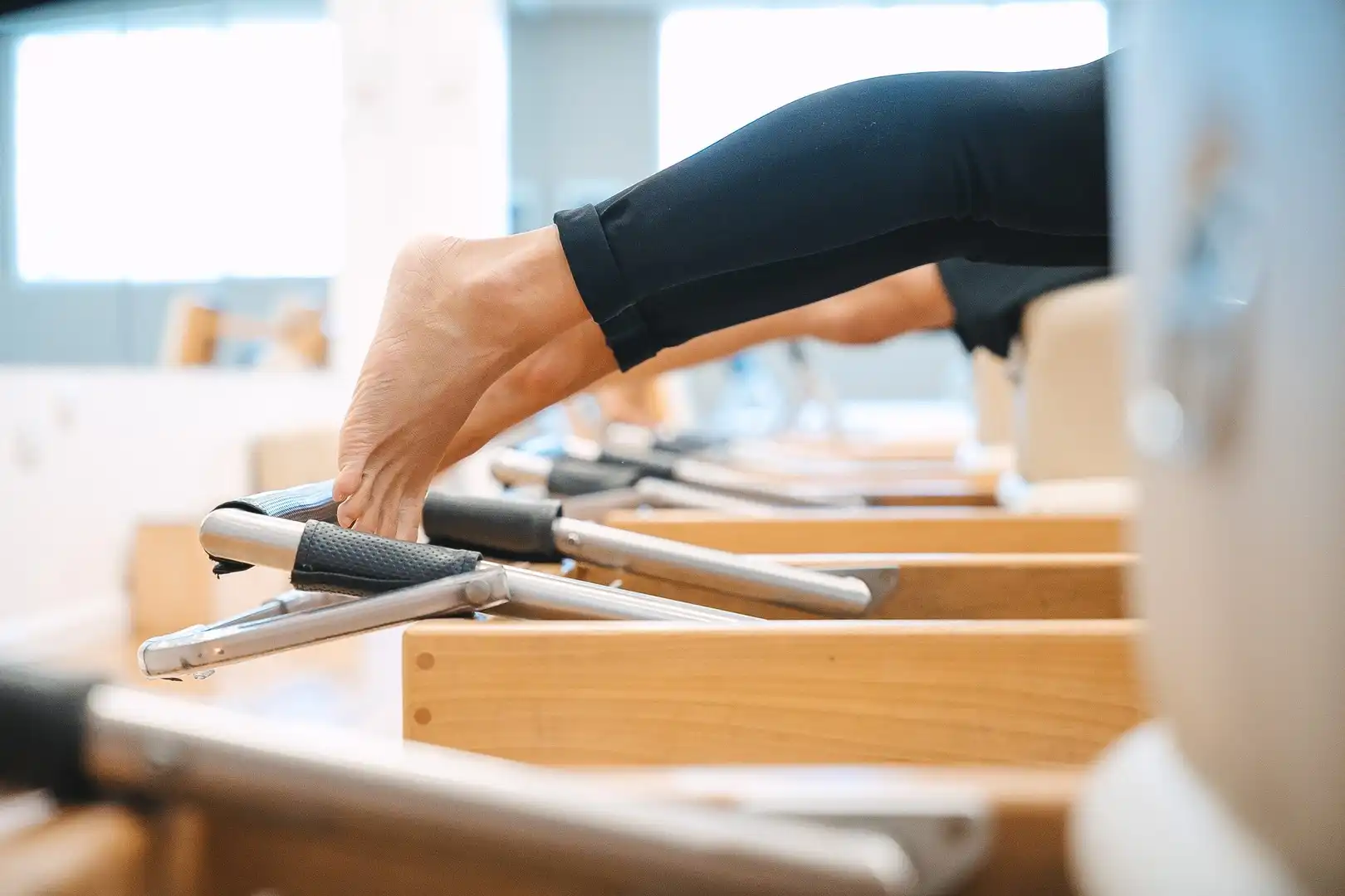 Detalle de una práctica de Pilates en un Reformer de madera
